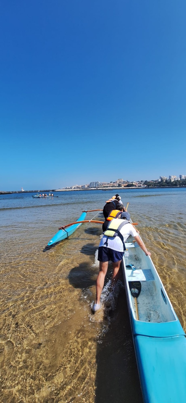 Equipa a lançar a canoa a partir da praia